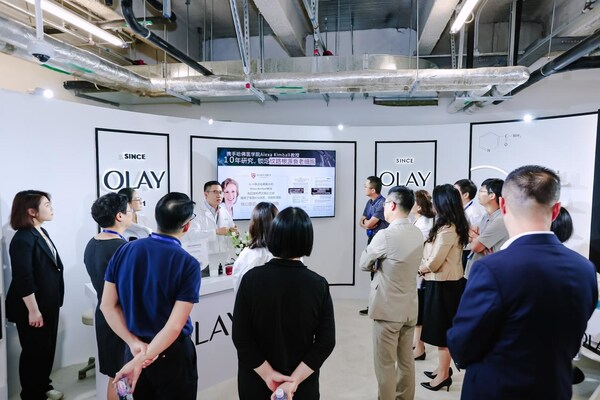 图为 OLAY 研发人员讲解新品淡纹黑管精华从根源淡化 6 大纹路